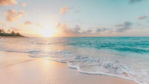 Close up view of a beach with a bright sunset in the distance on Oahu, Hawaii, USA